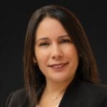 Debbie Roman with a short brown bob, and black blazer.